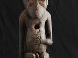 statue d'un singe assis sur un fond noir, avec un fond noir