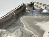 a silver tray with a handle on a white table