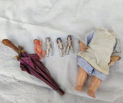 une poupée avec un parapluie et une paire de chaussures à côté d'une paire de ciseaux
