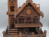 une maison de poupées en bois avec un balcon et un escalier