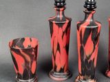 three vases and a glass sitting on a table