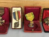 quatre médailles et une médaille se trouvent dans un écrin posé sur une table