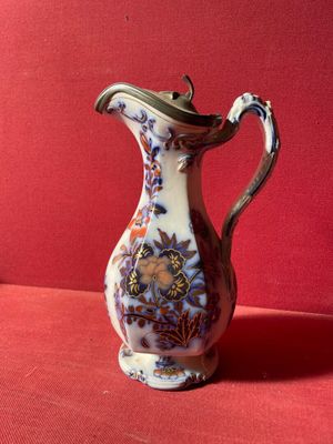 un vase blanc et bleu posé sur un fond rouge