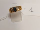 an image of a gold ring with a blue stone on it