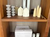 une étagère en bois sur laquelle sont disposés des bougies, des vases et d'autres objets