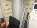 a chair in the corner of a room next to a refrigerator