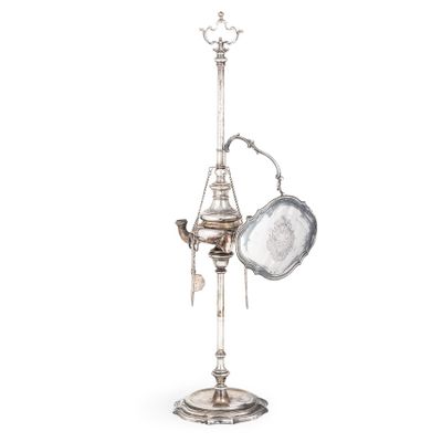 une lampe ancienne en argent plaqué, avec une casserole et une poêle posées sur un socle