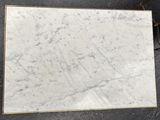 a white marble slab with a gold border on a black background
