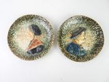 pair of ceramic portraits of a woman and a man on a plate