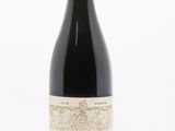 the bottle of wine is sitting on a white surface