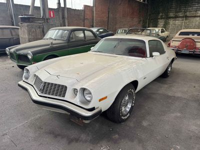 several old cars are parked in a garage next to each other