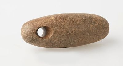 a rock with a hole in it on a white surface