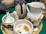 une table verte sur laquelle se trouvent des assiettes, des tasses et un vase