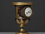 un vase doré et noir orné d'une horloge