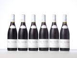 six bottles of wine lined up in a row on a table