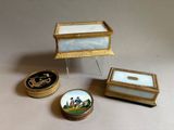 Trois boîtes miniatures sont posées les unes à côté des autres sur une table