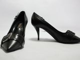 une paire de chaussures noires à talons hauts avec des boucles, posées sur un fond blanc