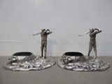 deux figurines en argent représentant un homme et une femme avec des clubs de golf