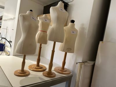 three mannequins sitting on a table in a room