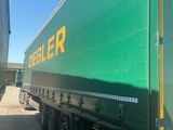 a large green semi truck parked in a parking lot