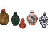 cinq petits vases posés les uns à côté des autres sur une surface blanche
