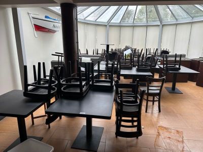 des tables et des chaises dans un restaurant, avec une verrière en arrière-plan
