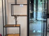une vitrine en verre avec des étagères et un porte-serviettes dans un coin