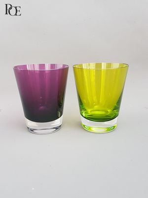 trois verres de couleurs différentes posés les uns à côté des autres sur une table