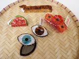 a tray with various items on it including a hair comb, a slice of watermelon, and a watermelon