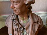 a bust of a man sitting on a wooden table