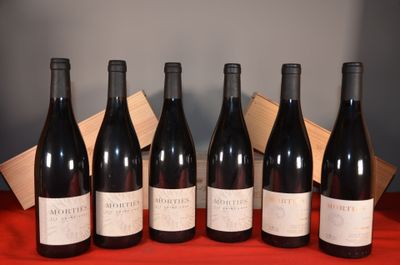 six bottles of red wine are lined up on a table