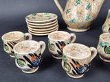 a group of cups and a teapot sitting on a table