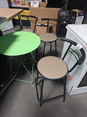 plusieurs chaises et une table dans une pièce équipée d'un poêle et d'un réfrigérateur