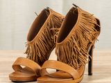 a close up of a pair of shoes with fringes on them