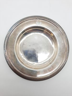 une assiette ancienne en argent sur fond blanc