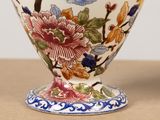 a close up of a vase with flowers on it