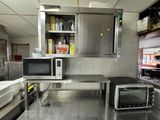stainless steel counter top in a commercial kitchen with a microwave and toaster oven