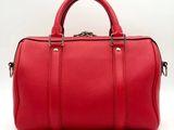 a red leather duffel bag on a white background
