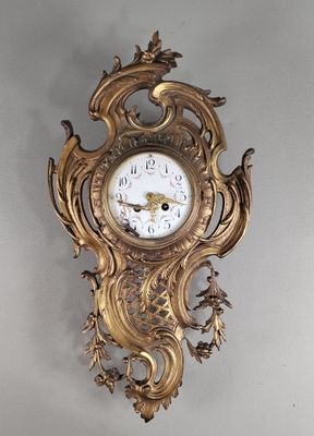 une horloge en or accrochée au mur de la pièce