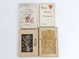 three books are sitting on a white surface with a white background