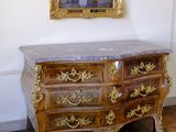 a marble top dresser in a room with a mirror on the wall
