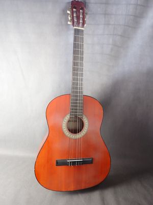 an orange guitar sitting on top of a white sheet