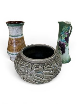 trois vases posés l'un à côté de l'autre sur une surface blanche