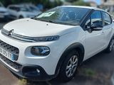 a small white car parked on the side of the road