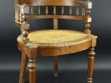 une image représentant une chaise en bois avec une assise en osier sur fond noir