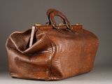 an image of a brown bag with a handle on a gray surface