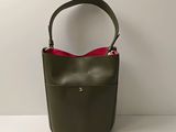 Le petit sac vert est muni d'une poignée rouge.
