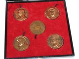 three gold medals in a red box with a red velvet lining