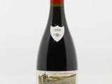 une bouteille de vin rouge posée sur une table blanche
