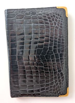 crocodile skin passport case with gold accents on a white background